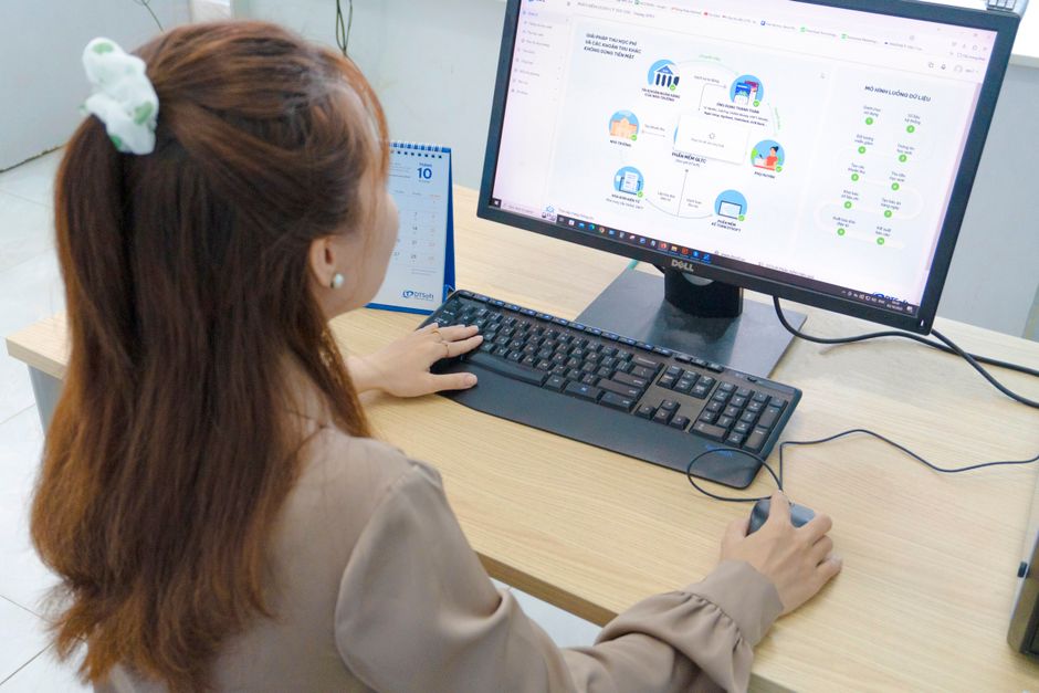 Young woman using desktop computer in office setting in Hanoi, Vietnam.