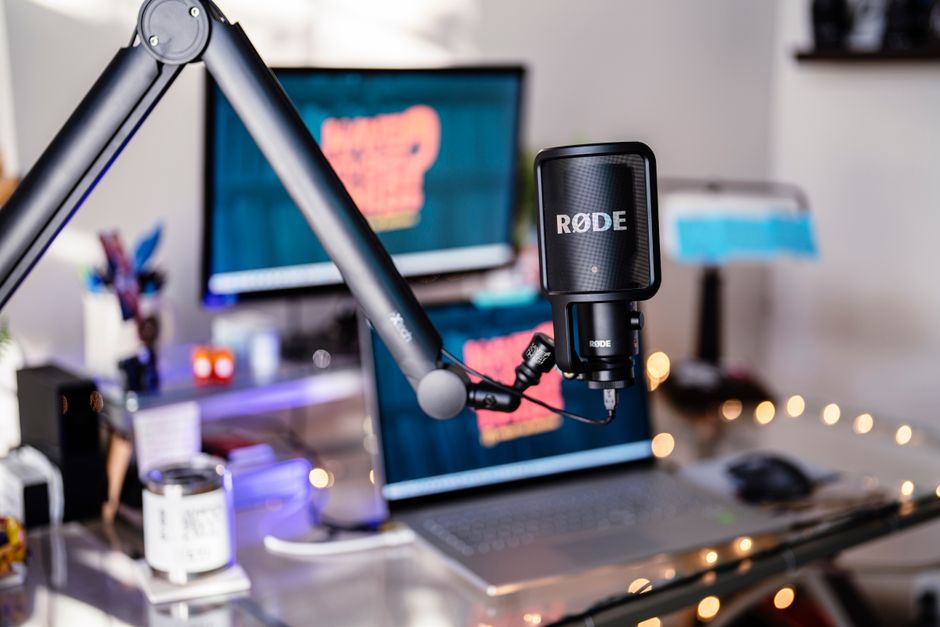 Close-up of a modern podcast studio featuring a RØDE microphone and digital workspace, ideal for content creators.