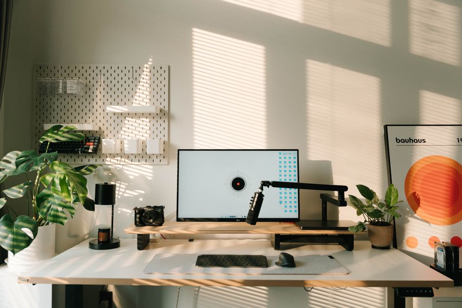 Bright and modern home office setup with desktop, plants, and minimalist design elements, perfect for a creative workspace.